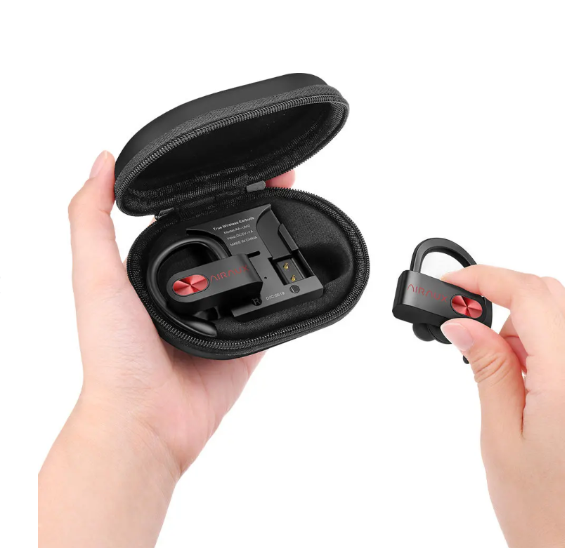 Charging case with wireless earbuds inside next to a cell phone